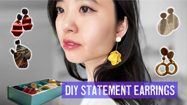 woman wearing polymer clay statement earrings, surrounded by multiple earrings