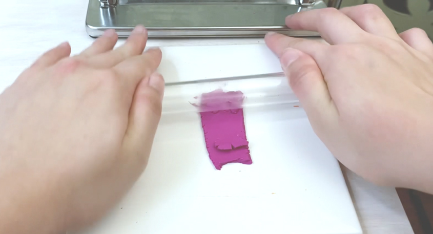 rolling brittle fushia clay with a roller