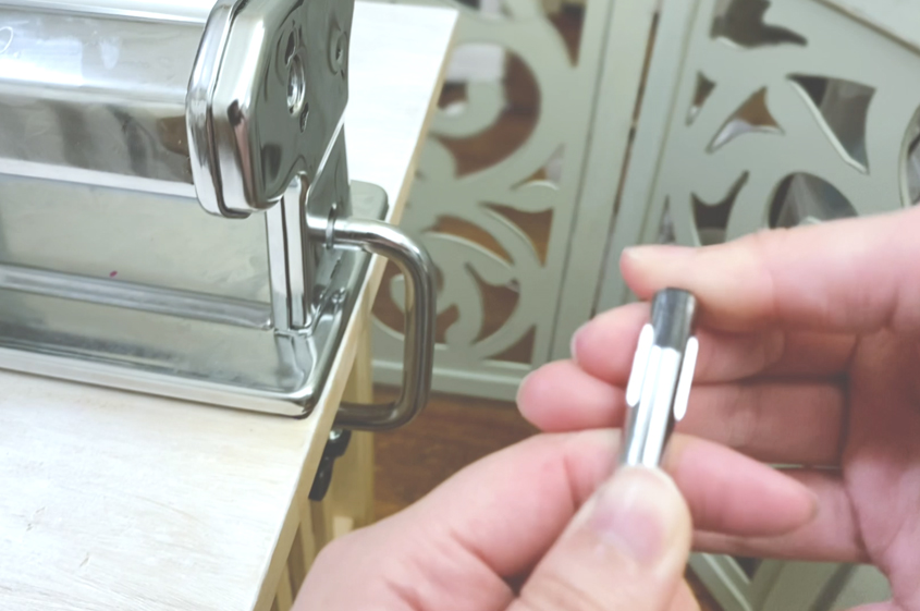 tapping black tape on the end of a pasta machine crank