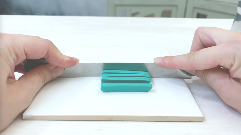 slicing turquoise clay into smaller pieces
